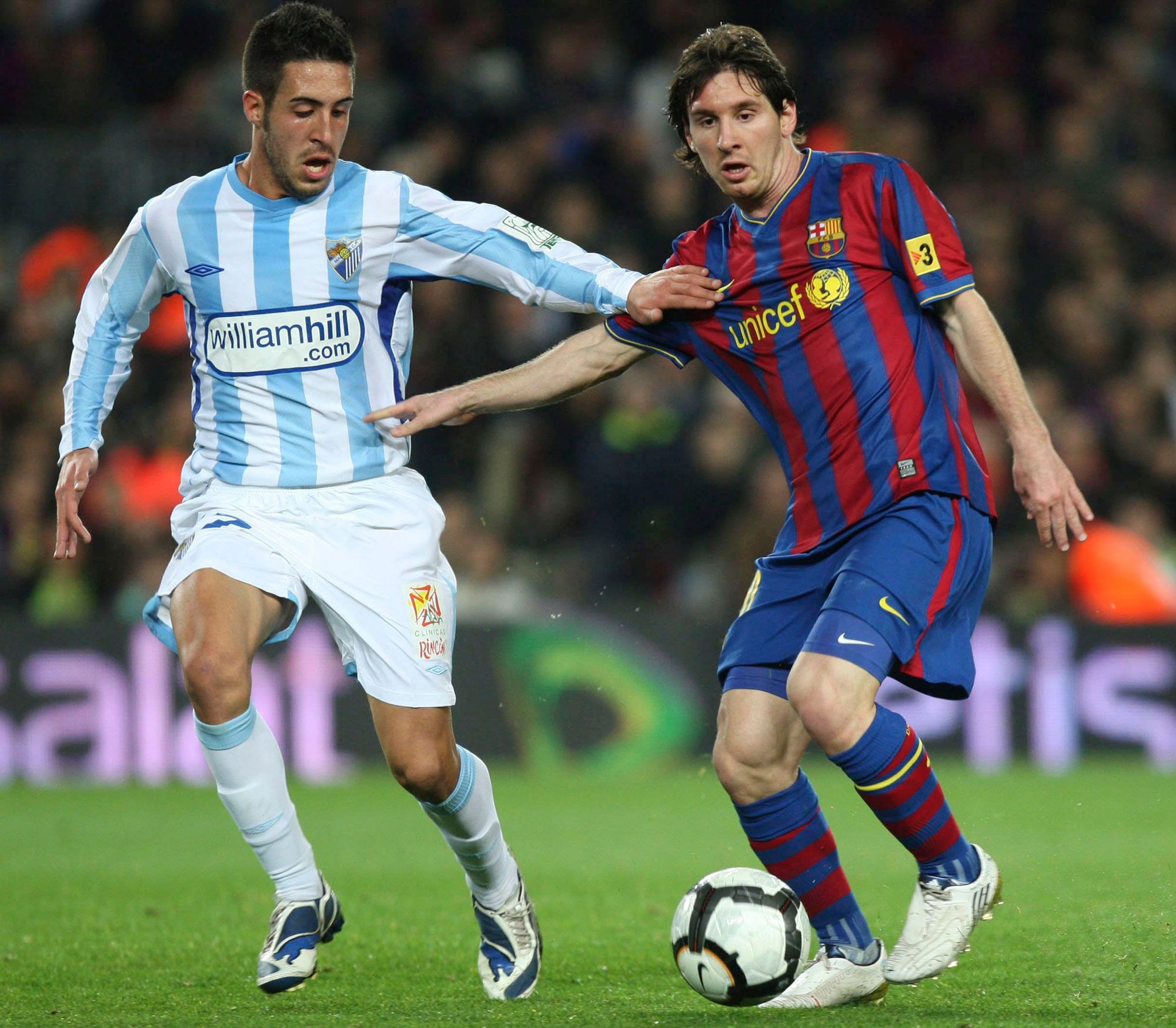 Dani Toribio disputa la pelota a Lionel Messi durante su etapa en el Málaga CF.